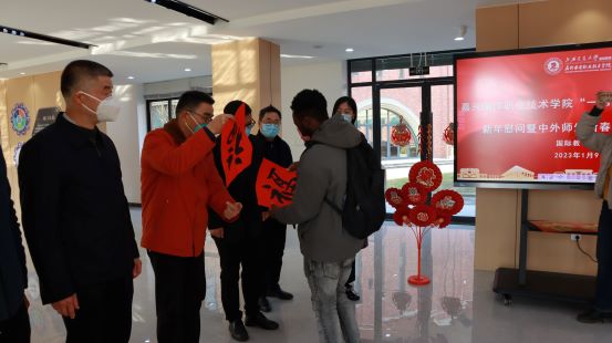 1673285640180488.jpg 图4 留学生逐一为校领导送上新春“福”字.JPG